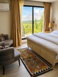 a bedroom with a bed and a large window at Lamhay Private lodges in Skardu