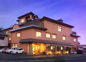 a large building with cars parked in a parking lot at 旅館かわな -Ryokan Kawana- in Kimitsu