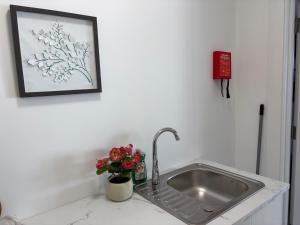 a kitchen sink with a vase of flowers on a counter at Cosy apartment - Na Creagáin in Tully