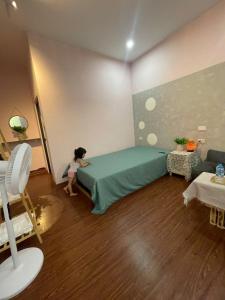 a little girl playing with a bed in a room at BalaHomestay BalaHouse in Lạc Thành