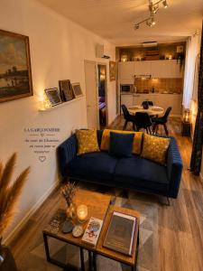a living room with a blue couch and a table at La Garçonnière appartement climatisé in Charolles