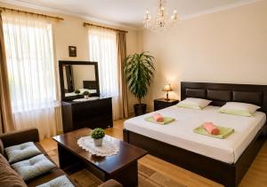 a bedroom with two beds and a couch and a mirror at Mountain Home Inn-Guesthouse in Lagodekhi
