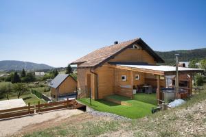 a small wooden house on a hill with green grass at Villa Velebita House for 9 near Plitvice Lakes in Rudopolje