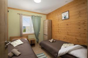 a bedroom with two beds and a window at Villa Velebita House for 9 near Plitvice Lakes in Rudopolje +45 photos