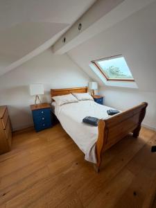 a bedroom with a large bed with a skylight at Ysgol Hill Main House in Rosebush +8 photos