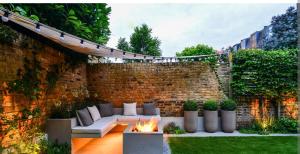 a patio with a fire pit and a brick wall at The corbett story in Rāmnagar