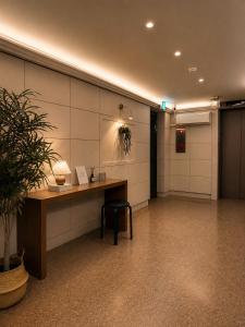 a waiting room with a desk and a potted plant at Stay PAUSE in Bucheon