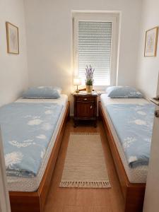 two twin beds in a room with a window at Villa Jurisic in Tučepi