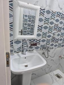 a bathroom with a sink and a mirror at Thebes Guest house in Jazīrat al ‘Awwāmīyah +44 photos