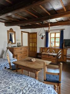 a living room with a table and a bedroom at Zora Vendégház in Tihany