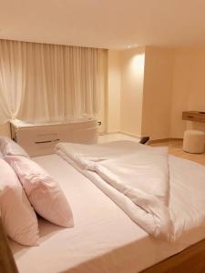 a large white bed in a room with a window at Pyramids view M in Cairo