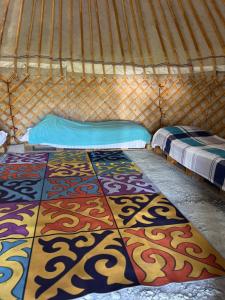 a yurt with two beds and a rug on the floor at ЭКО -Балык 