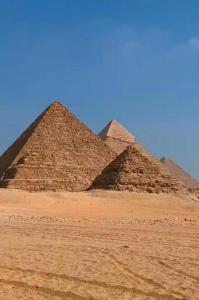 two pyramids in the desert under a blue sky at Pyramids view M in Cairo +43 photos