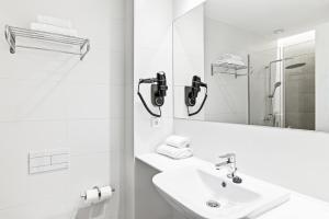 a white bathroom with a sink and a mirror at B&B HOTEL A Coruña Aeropuerto in Culleredo +26 photos