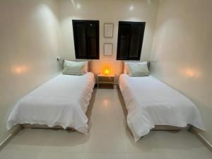 two beds in a room with a light on it at Villa Émeraude in Marrakesh +20 photos