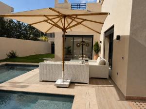 a patio with an umbrella next to a pool at Villa Émeraude in Marrakesh