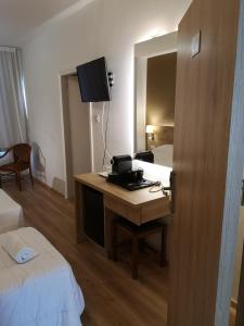 ein Hotelzimmer mit Schreibtisch, Bett und Spiegel in der Unterkunft Ekali Hotel in Kakopetria + 23 Fotos