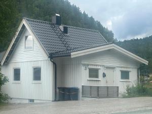a white house with a gambrel roof at Bolig leies ut med 3 soverom in Namsos