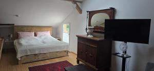 a bedroom with a bed with a mirror and a dresser at Altes Saale Fährhaus in Naumburg