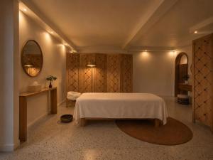 a bedroom with a white bed and a mirror at Aishi Machame in Moshi