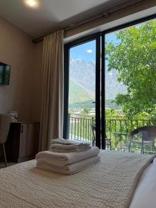 a bedroom with a bed with a view of a mountain at Hotel Sweet Night in Kazbegi