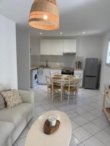 a kitchen and living room with a table and a couch at Pavillon Le Luc in Ozillac