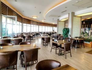 a restaurant with tables and chairs and windows at Kule Hotel & Spa in Gaziantep