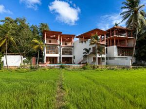 a house with a green field in front of it at Navi - Boutique Hotel - Adults Only in Ahangama