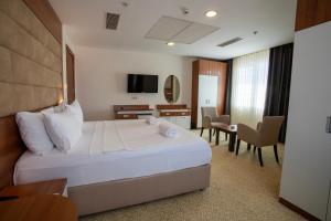 a hotel room with a bed and a table and chairs at Kule Hotel & Spa in Gaziantep +61 photos