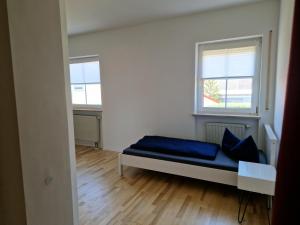 a white room with a bed and two windows at Apartment Stark in Merkendorf