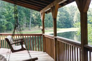 a swing on a porch with a view of a lake at The Lake House A Hidden Gem Sleeps 4 in Columbia
