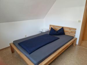 a bedroom with a bed with a blue bedspread and blue pillows at Apartment Stark in Merkendorf +7 photos