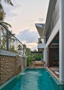 a swimming pool in front of a house at Charlie Hotel in Kakani