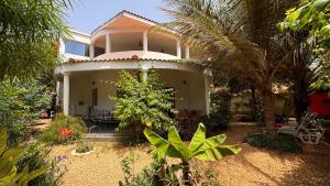 a house with a palm tree in front of it at Villa La Pommone in Somone