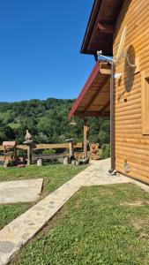 a wooden building with a roof and a grass yard at Un Rio Sana in Gornji Ribnik