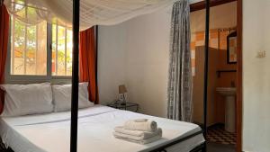 a bedroom with a bed with white towels on it at Villa La Pommone in Somone