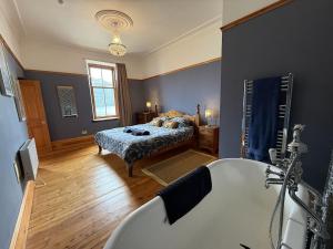 a bathroom with a bed and a bath tub at Stunning Hideaway on Loch Goil in Carrick