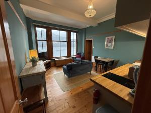 a living room with a couch and a table at Stunning Hideaway on Loch Goil in Carrick +15 photos
