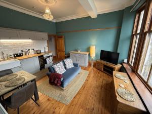 a living room with a couch and a tv at Stunning Hideaway on Loch Goil in Carrick