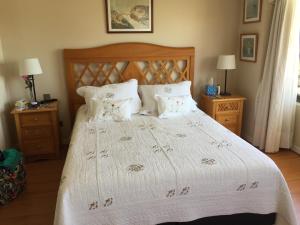 1 dormitorio con 1 cama blanca grande y 2 mesitas de noche en Apartamento Edificio Genova, en Viña del Mar