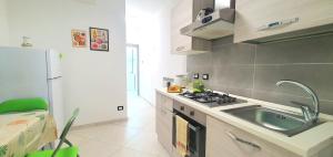 a kitchen with a sink and a stove and a refrigerator at Dei Della Costiera in Agerola