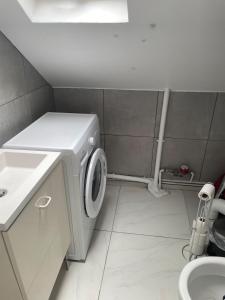 a bathroom with a washing machine and a sink at Proche métro Line 4 RER B in Bagneux