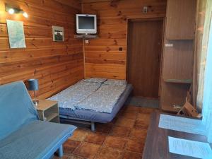 a room with a bed and a tv on a wall at Agroturystyka TWÓJ RAJ - Pokój dla 4 osób in Łuka