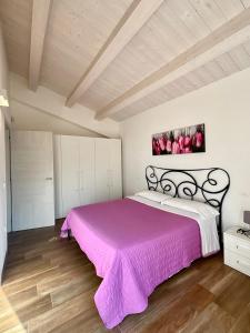 ein Schlafzimmer mit einem Bett mit einer rosa Decke in der Unterkunft Relais Villa Sofia in Calcinelli