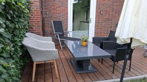 a table and chairs on a wooden deck at Haus Küstenglück in Neuharlingersiel