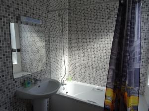 a bathroom with a tub, sink and mirror at The Gatwick White House Hotel in Horley