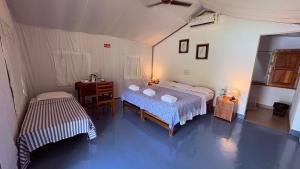 a bedroom with a bed and a table and a desk at Birds Murmur Camp in Kotamangalam