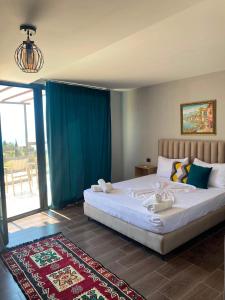 a bedroom with a large bed and a large window at Vila zaho in Dhërmi