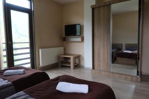 a room with two beds and a large mirror at Hotel Marli in Arsha