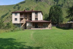 a house with a large yard in front of a mountain at Hotel Marli in Arsha